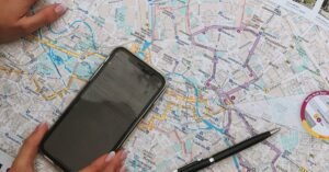 Hands interact with a Berlin map and smartphone, highlighting travel planning.